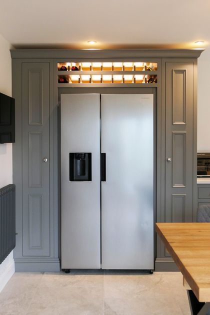 Bespoke grey cabinetry built around an American-style fridge-freezer with a wine rack above