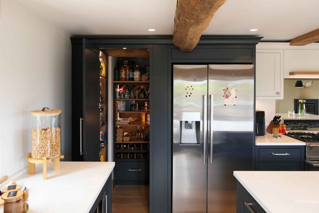 a handcrafted bespoke shaker kitchen painted in a dark grey colour featuring a custom walk in larder cupboard