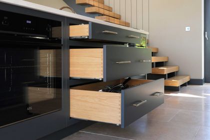 Open drawers revealing solid oak dovetailed drawer boxes in dark navy Shaker cabinetry