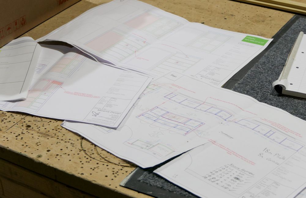 Technical bespoke kitchen workshop plans laid out on a worktop