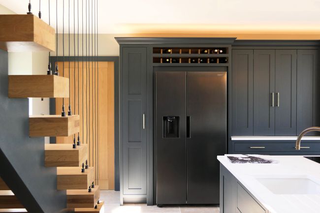 Dark navy Shaker kitchen with an integrated American-style fridge-freezer, a built-in oak wine rack and oak panelling