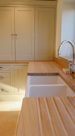 A kitchen with a light-coloured countertop, a sink, and cabinetry.