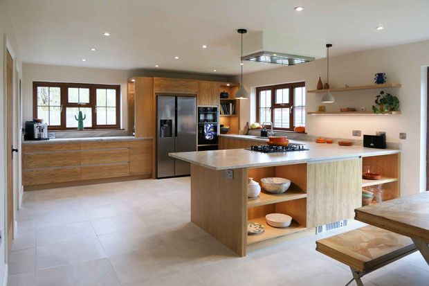 Modern kitchen with wood cabinets, large windows, stainless-steel appliances, and a peninsula with a gas cooktop.