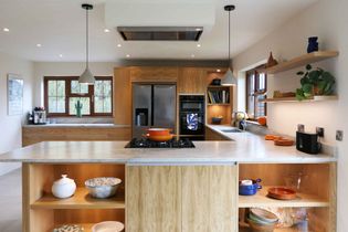 Overview of the modern oak kitchen showing the open shelving and large double fridge-freezer in the background located in credenhill.
