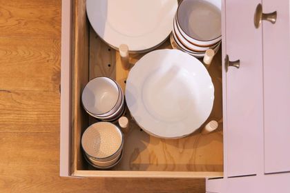 Deep drawer with peg dividers holding plates and bowls