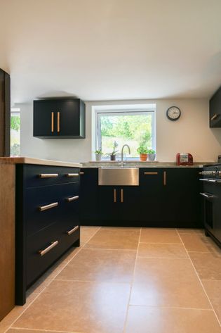 Navy blue modern kitchen with solid oak bar handles and exposed front sink