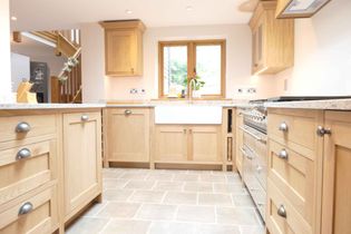 Shaker kitchen with oak cabinets, granite countertops, and stainless steel appliances. Bright and organized, featuring a skylight above.