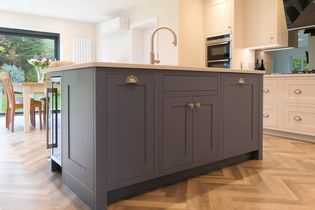 Blue shaker kitchen island with silver handles and quartz worktop.