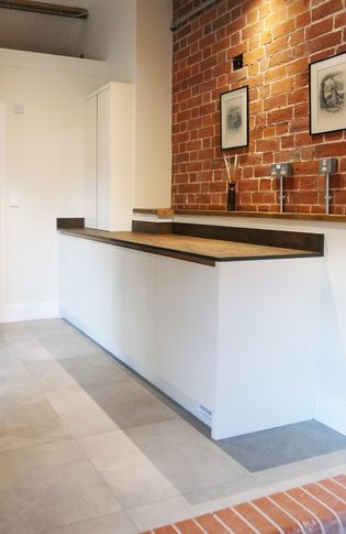 A simple white utility room just off the kitchen with multiple cupboards for appliances and storage