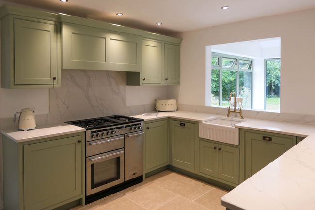 Green Shaker kitchen with apron fronted sink, range cooker and wall cabinets