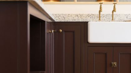 Deep burgundy Shaker kitchen with brass knobs, a granite worktop and a butler sink