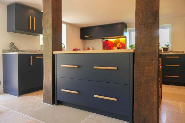 Navy Molveno slab kitchen with oak bar handles and a colourful glass splashback