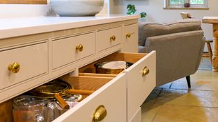 Open Shaker kitchen drawers display pots, bowls, strainers, measuring cups, and utensils.