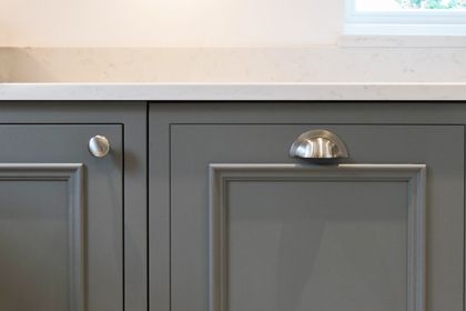 Close up of grey Florence Shaker cabinetry showing the signature bolection moulding with cup and knob handles