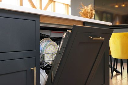 Integrated dishwasher set into rigid, hardwearing dark navy Shaker cabinetry