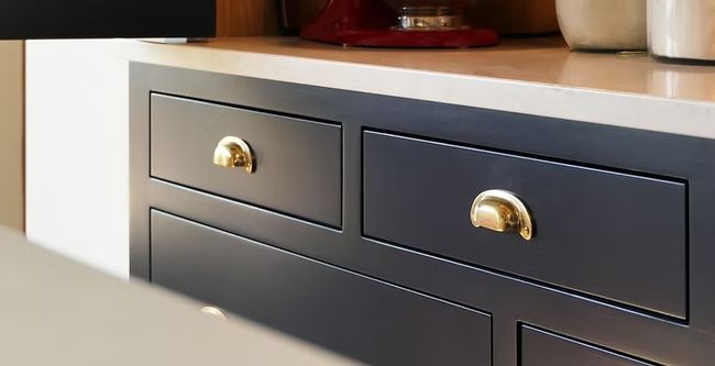 Dark kitchen drawers with solid brass cup handles