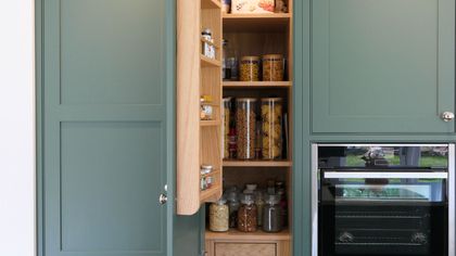 Green Shaker larder with a built-in oak door spice rack and integrated storage