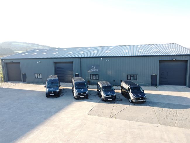 Minerva workshop with four parked vans outside 