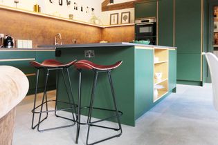 A modern kitchen featuring a green island with bar stools, wooden accents, and a simple, minimalist design.