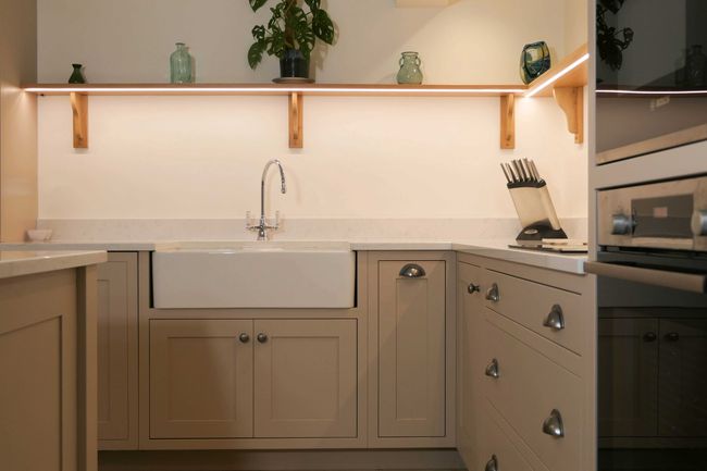 Pale shaker kitchen with apron front sink and nickel cup handles