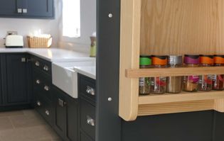 Close-up of a sleek, shaker style dark grey wine rack with vertical grooves. The rack holds three bottles, emphasizing elegance and organization.