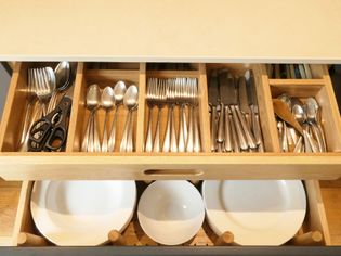 Peg drawer holding crockery with secret utensil drawer above.