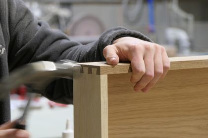 Cabinetmaker assembling a solid oak dovetail drawer box by hand